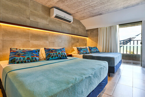imagem do quarto com duas camas de casais com ar condicionado e uma varanda.